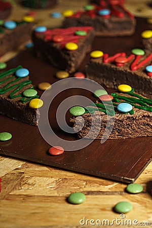 Closeup shot of decorative Christmas tree biscuits on a wooden board Stock Photo