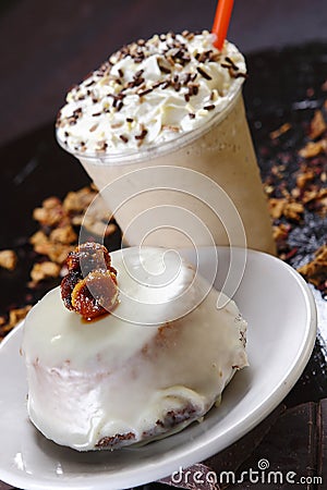Closeup shot of the delicious creamy pastry with a cup of frappuccino with whipped cream Stock Photo