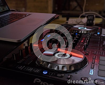 Closeup shot of a DJ mixer with a laptop on top Editorial Stock Photo