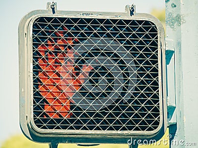 Closeup shot of an electric crosswalk sign with red hand signalling to stop walking Stock Photo