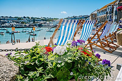 Closeup shot of empty deck chairs and flower pots overlooking the harbor on a sunny day Editorial Stock Photo