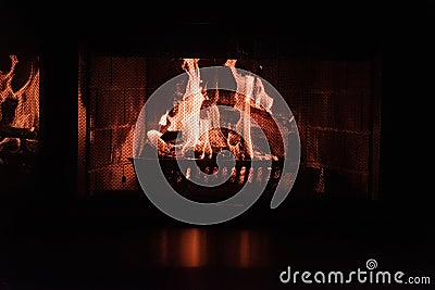 Closeup shot of a fire in a brick fireplace with screen Stock Photo