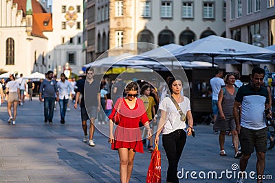 Closeup shot of friends enjoying the sunny evening together at Munich Marienplatz Editorial Stock Photo