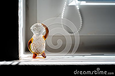 Closeup shot of glass monkey figurine on the window Stock Photo