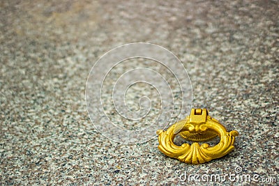 Closeup shot of a golden handle of a stone grave on stone marble Stock Photo