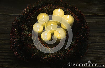 Closeup shot of a group of seven burning candles on a black background Stock Photo