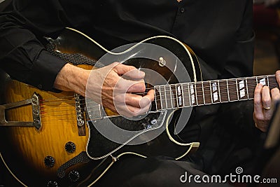 Closeup shot of a guitarist playing his guitar. Stock Photo