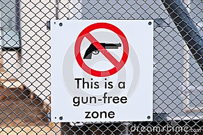 Closeup shot of a gun-free zone sign on a fence Stock Photo