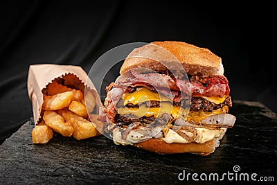 Closeup shot of a hamburger and frie on an isolated black background Stock Photo