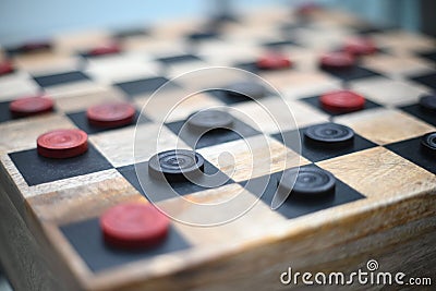Closeup shot of a handmade wood checkers game with red and black squares Stock Photo