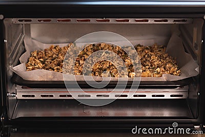 Closeup shot of healthy oats and nuts on a sheet in the oven Stock Photo