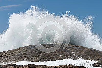 Closeup shot of huge brown sea stone and wave splash Stock Photo