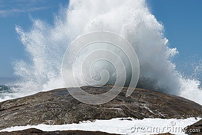 Closeup shot of huge brown sea stone and wave splash Stock Photo