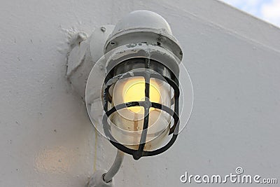 Closeup shot of the illuminated light bulb on the white wall of the boat Stock Photo