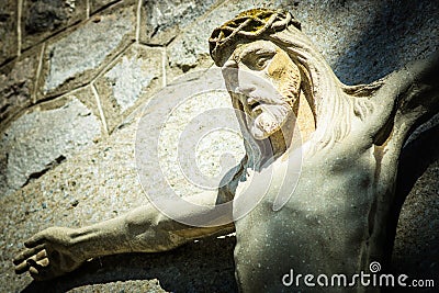 Closeup of Jesus Christ on the Cross - Concrete Sculpture on Catholic Church in Croatia Stock Photo