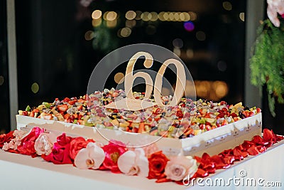 Closeup shot of a large square 60th birthday cake with flowers Stock Photo