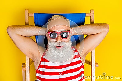 Closeup shot of lying sunbed funny chilling cool pensioner gray bearded man take nap at local beach isolated over yellow Stock Photo