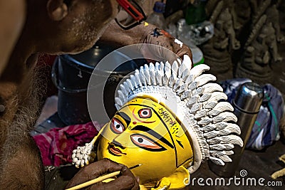 Closeup shot of a man painting the face of Goddess Durga in preparations for the Durga Puja festival Editorial Stock Photo