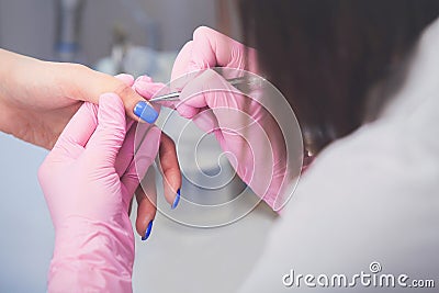 Closeup shot of manicurist in pink rubber gloves makes hand painting fingernails with brush Stock Photo