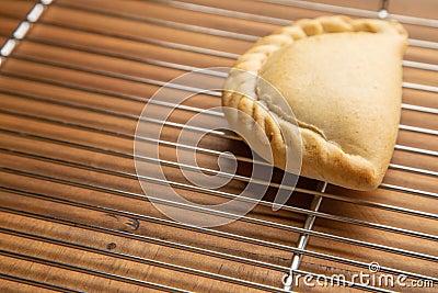 Closeup shot of a meat empanada on a wooden background Stock Photo