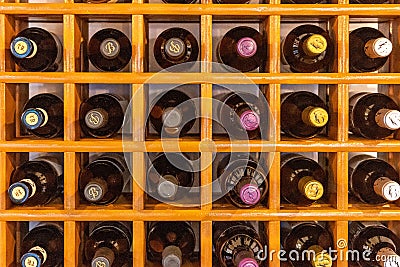 Closeup shot of an orange rack with bottles of wine Editorial Stock Photo