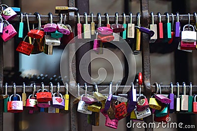 Closeup shot of the padlocks hanging on wall as symbols of love. Italy Editorial Stock Photo