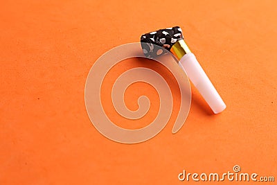 Closeup shot of a party noisemaker isolated on an orange background Stock Photo