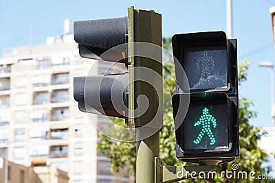 Closeup shot of a pedestrian traffic lights showing red and green with trees on the background Editorial Stock Photo
