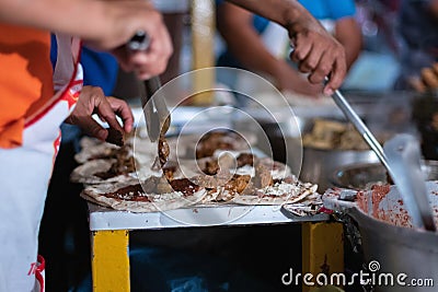 Closeup shot of people preparing iconic Honduran street food baleada outdoors Stock Photo