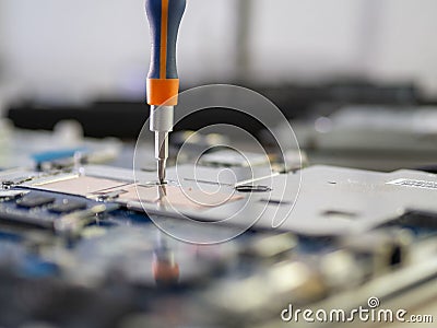 Closeup shot of a person repairing a tablet with a screwdriver Stock Photo