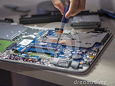 Closeup shot of a person repairing a tablet with a screwdriver Stock Photo
