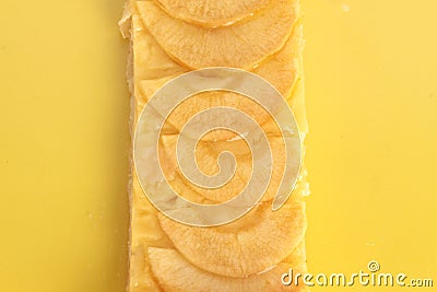 Closeup shot of a piece of apple pie on a yellow surface Stock Photo