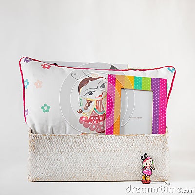 Closeup shot of a pillow with cute drawings on it and picture frames in a box Stock Photo