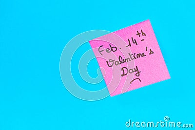 Closeup shot of a pink romantic Valentine's Day note on a blue surface Stock Photo