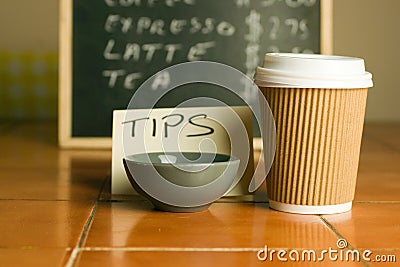 Closeup shot of plastic coffee cup and bowl for tips with a pricelist background Stock Photo