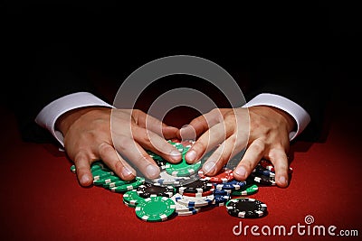 Closeup shot of a poker player taking a big pile of poker chips Stock Photo