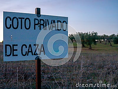 Closeup shot of a poster for a private hunting reservation in an olive grove under the blue sky Stock Photo