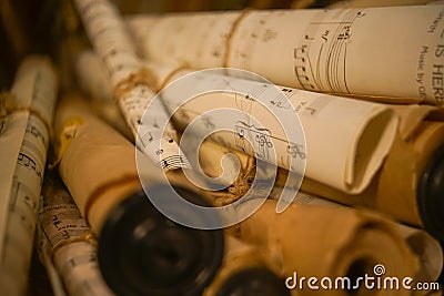 Closeup shot of rolled-up sheets of vintage music songs scrolls with different notes Editorial Stock Photo