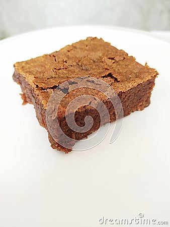 Closeup shot of a single slice of delicious brownie on a white plate Stock Photo