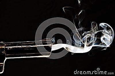 Closeup shot of a smoking gun with s black background Stock Photo