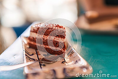 Closeup shot of a tasty red velvet cake slice served on a vintage patterned tray Stock Photo