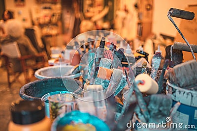 Closeup shot of various paintbrushes, tubes of paint, artistic tools and equipment in a studio on a Stock Photo