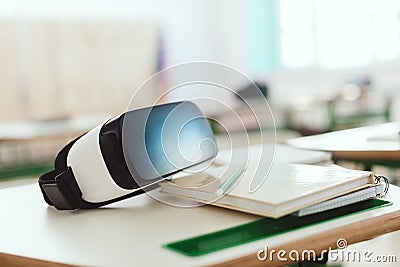 Closeup shot of virtual reality headset on table with textbook and pencil Stock Photo