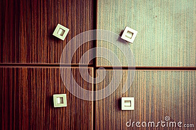 Closeup shot of a wooden closet with four doors with small square handles Stock Photo