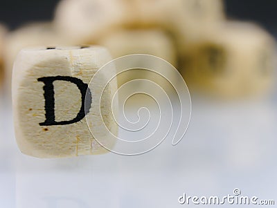 Closeup shot of a wooden cube with the letter D on a blurred background Stock Photo