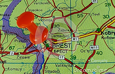 Closeup shot of a world map with a red pushpin pointing the city of Brest in Belarus Stock Photo