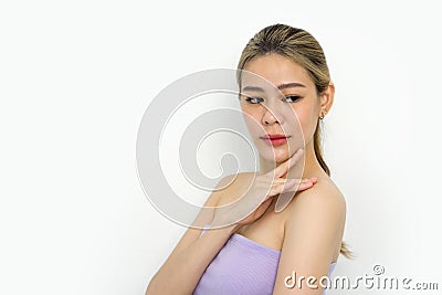 A closeup shot of young woman delicately touching her face, revealing details of her fingers, nails, and facial texture. Her eyes Stock Photo