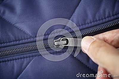 Closeup shot of a zipper on a blue jacket. Unzip a zip Stock Photo