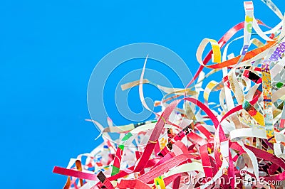 Closeup shredded paper texture and reuse red,yellow,colorful paper scrap of document on blue color background. Selective focus ima Stock Photo