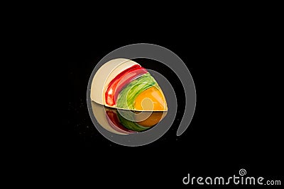 Closeup single shell-shaped colorful chocolate candy with reflection Stock Photo
